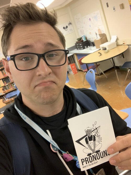 A selfie of a teacher posing with a copy of the zine.